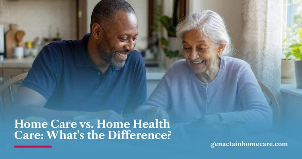 A smiling caregiver and an older woman look through a photo album over tea at a sunny kitchen table.
